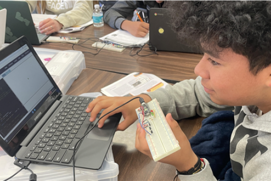Student infront of computer with a keyboard