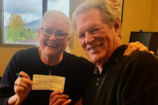 Carstons holding a check