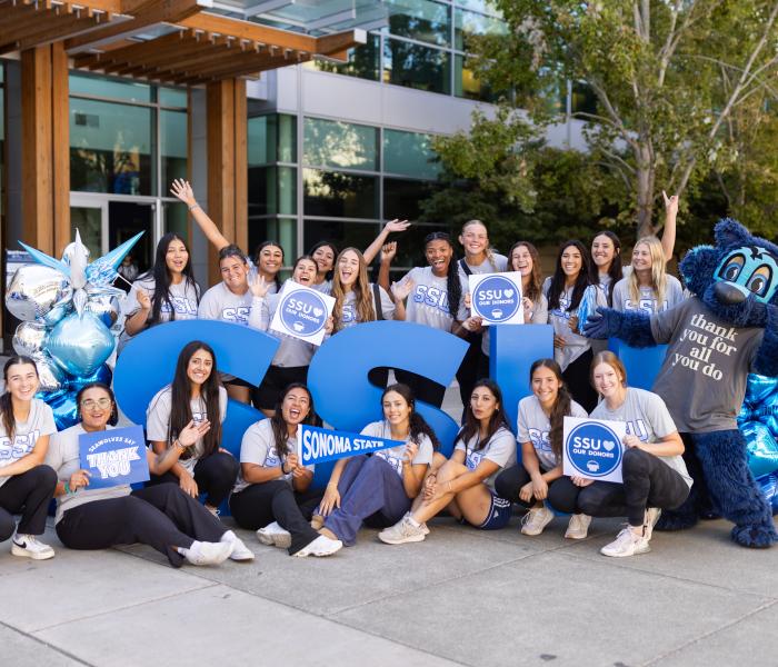Group of students holding thank you signs to donors