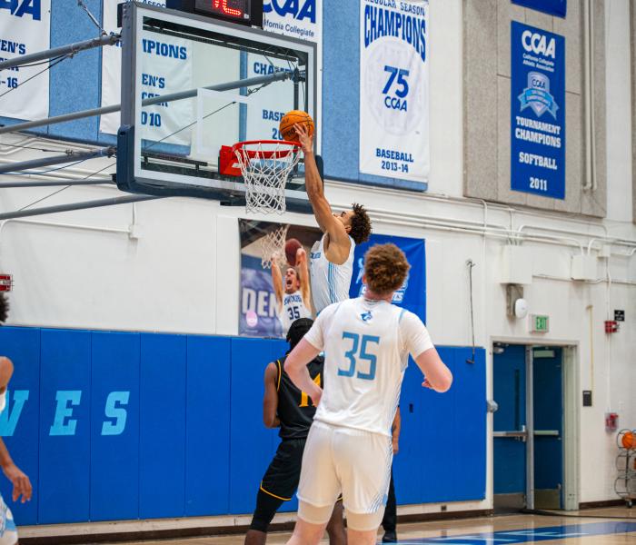 Student putting basketball through hoop