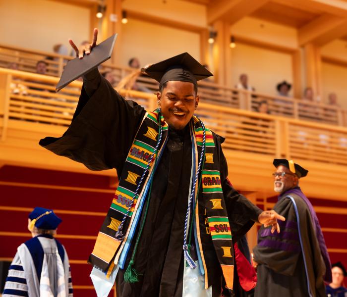 Student dancing after receiving diploma