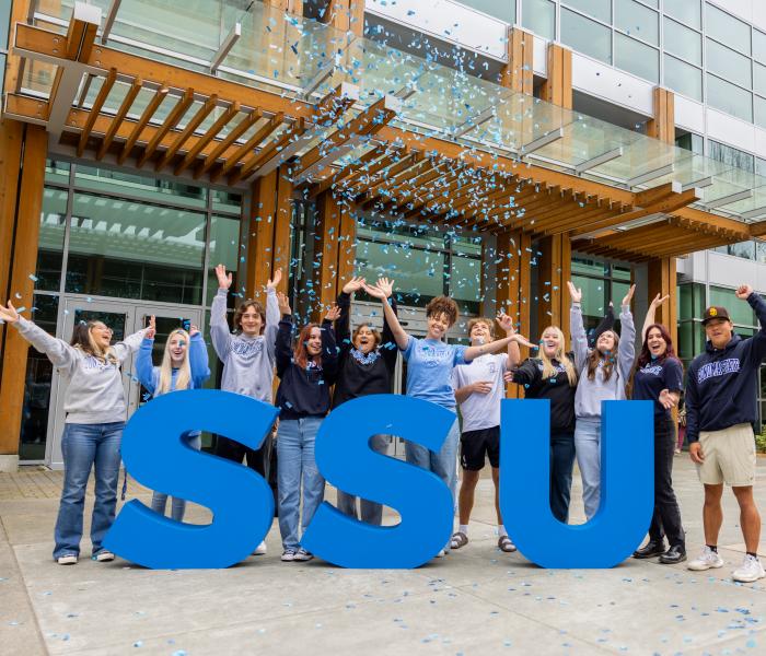 Students celebrating behind the SSU letters