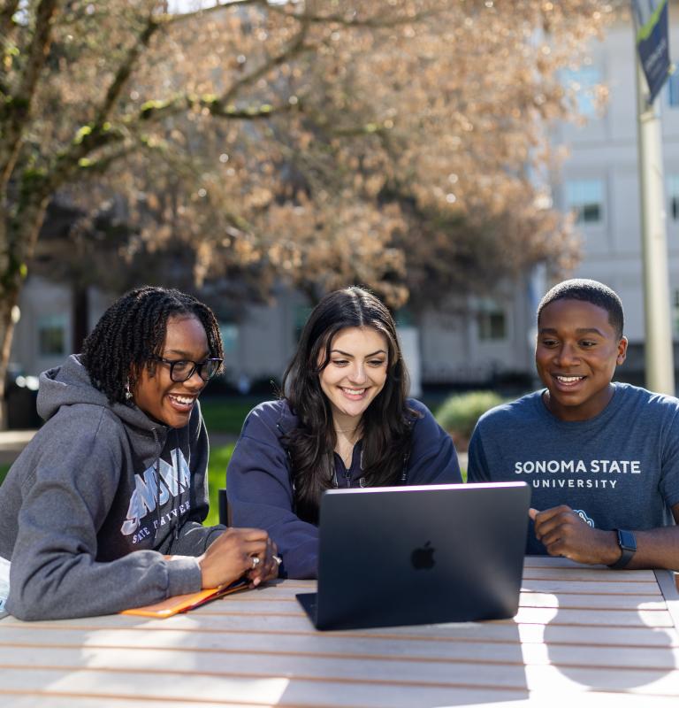 Three students looking at a computer