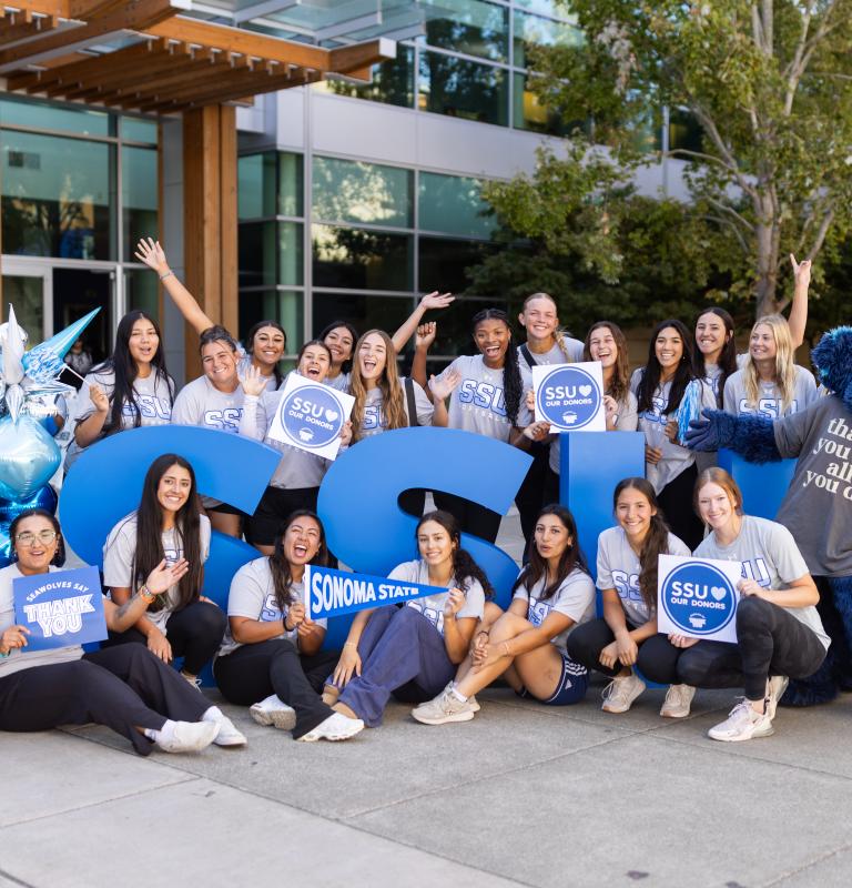 Group of students holding thank you signs to donors