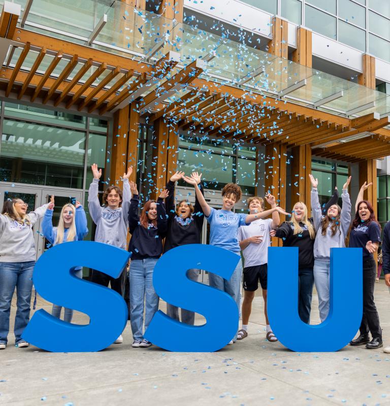 Students celebrating behind the SSU letters