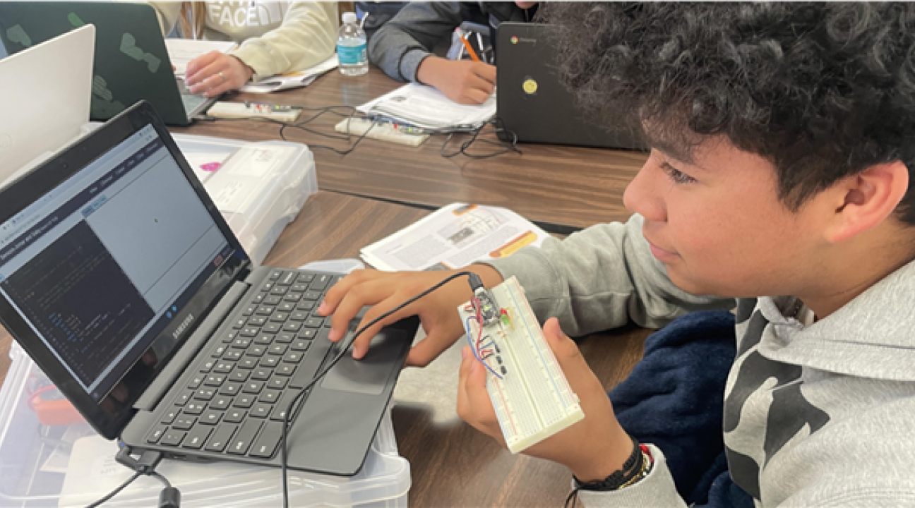 Student infront of computer with a keyboard