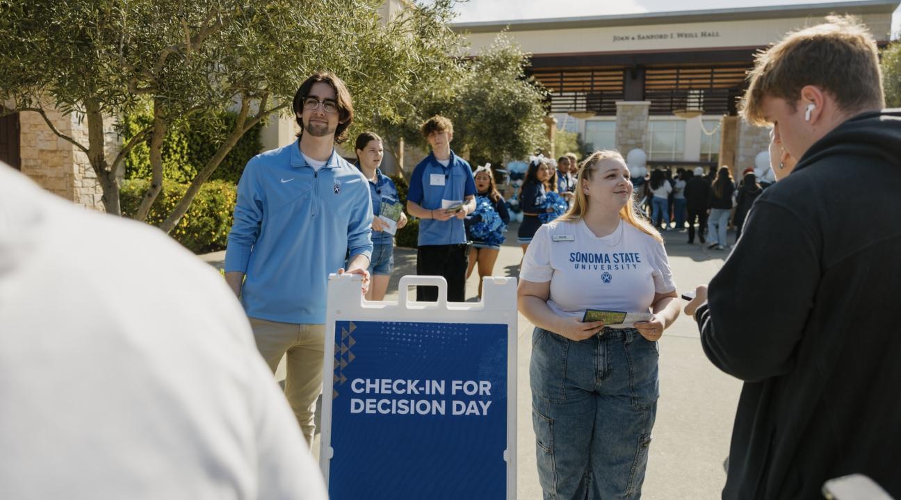 Sonoma State University student ambassador Denise Bevis (right, facing camera) greets prospective students at SSU Decision Day 2024