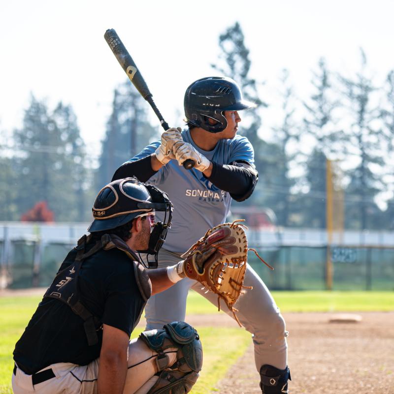 Student holding bat in their hand and catcher holding a glove