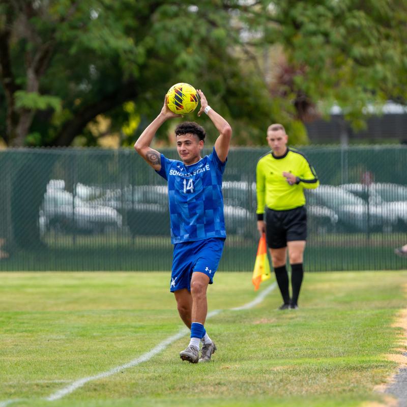 Student throwing a ball over their head onto the soccer field