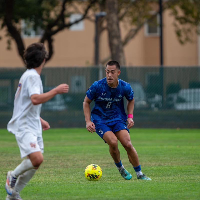 Student running with a soccer ball at their feet