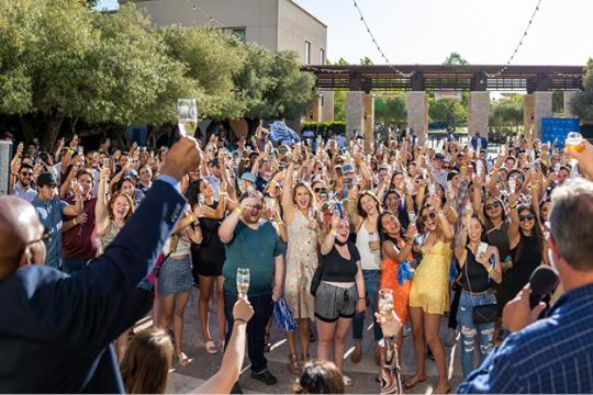 Students holding up glasses of champagne to Toast at Toast of Town event