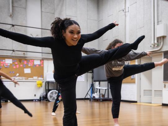 Student dancing with hands up in the air