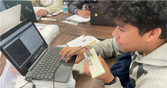 Student infront of computer with a keyboard