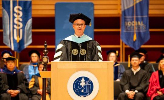 Dr. Nathan Evans standing at a podium at commencement