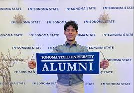 Carlos Calito holding Sonoma State Alumni sign