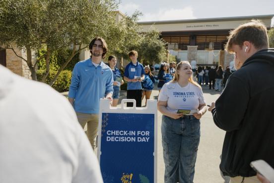 Sonoma State University student ambassador Denise Bevis (right, facing camera) greets prospective students at SSU Decision Day 2024