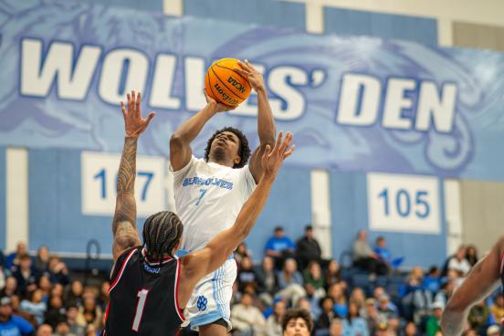 An SSU student dunking a basketball while playing on the Men's Basketball team