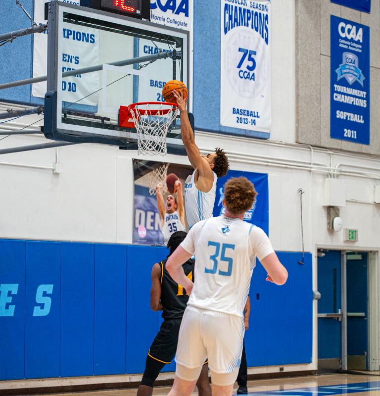 Student putting basketball through hoop