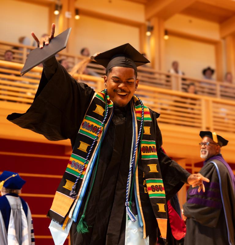 Student dancing after receiving diploma