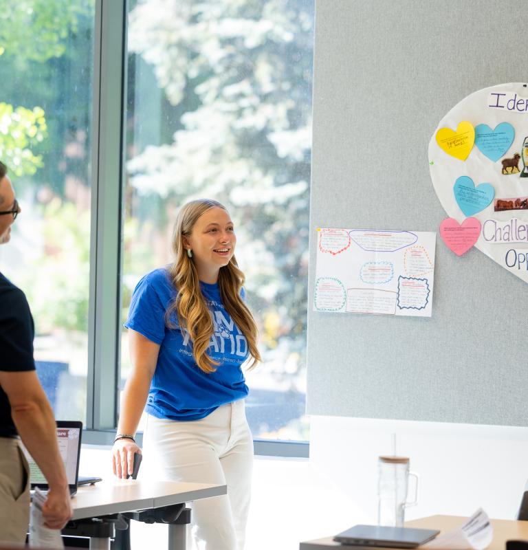 Three students talking in a group and standing