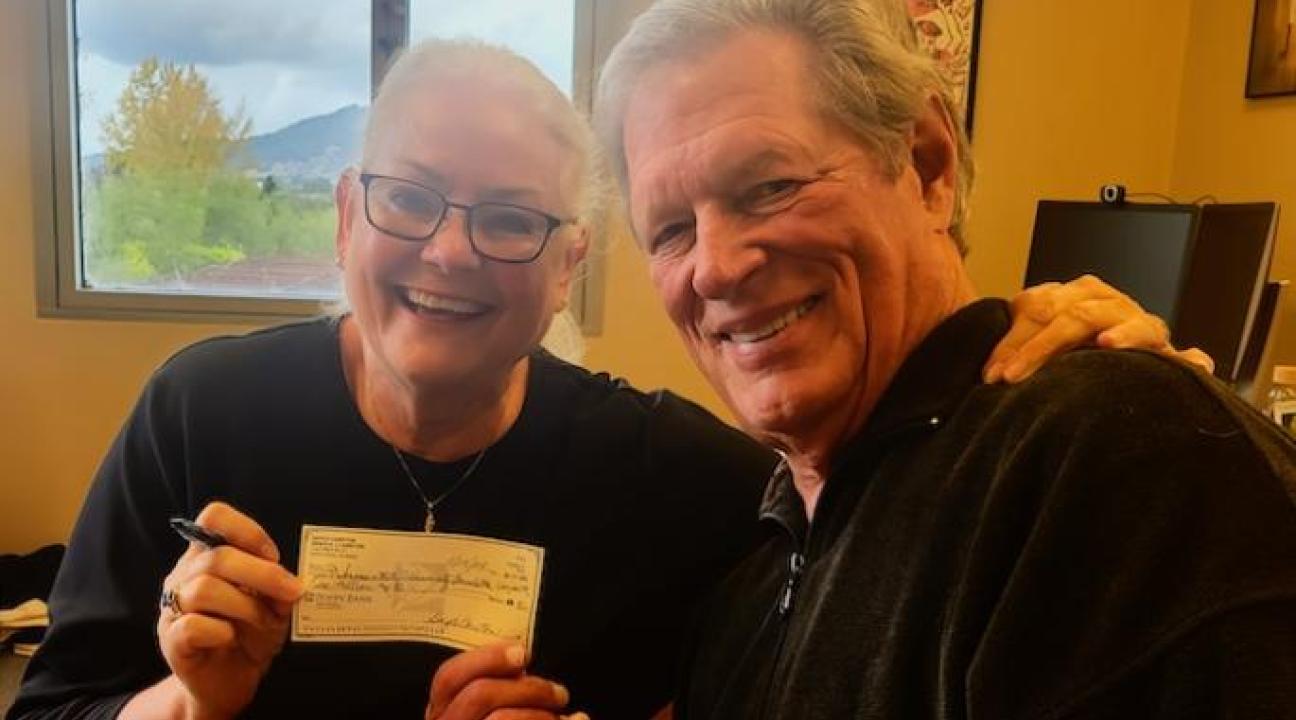 Carstons holding a check