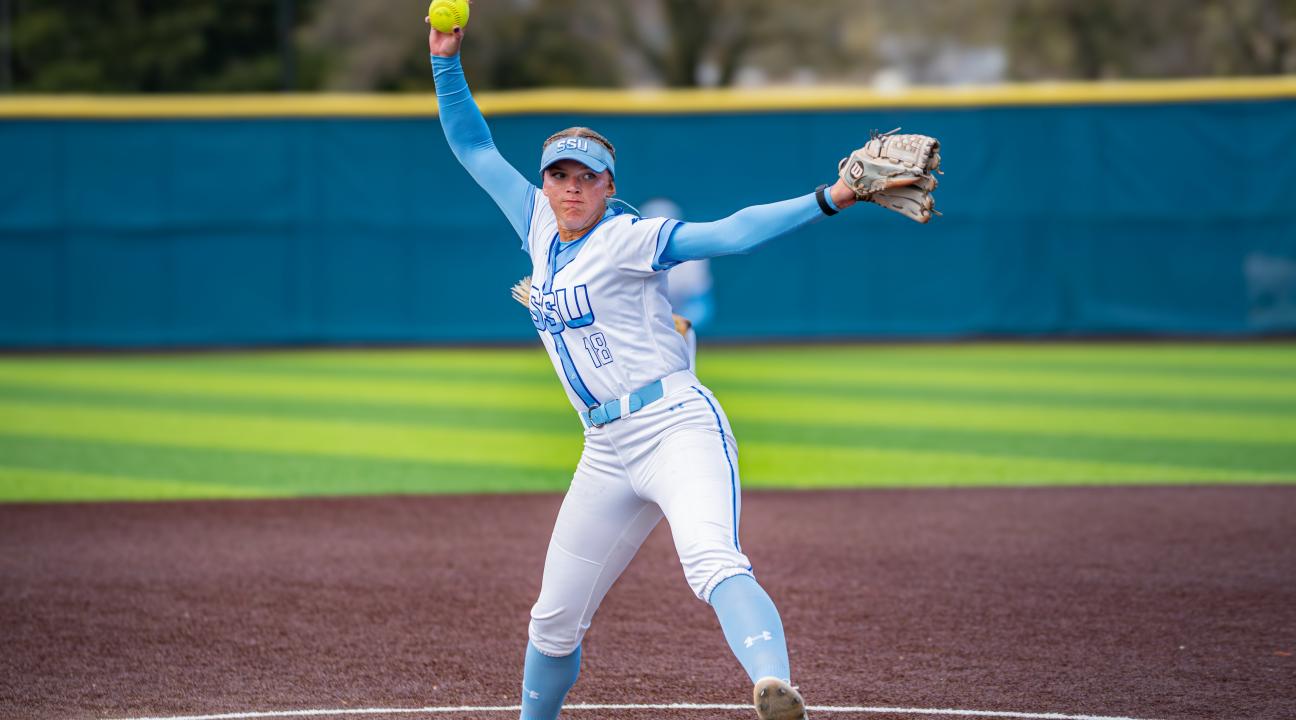 An SSU student pitching a ball while playing on the Women's Softball team