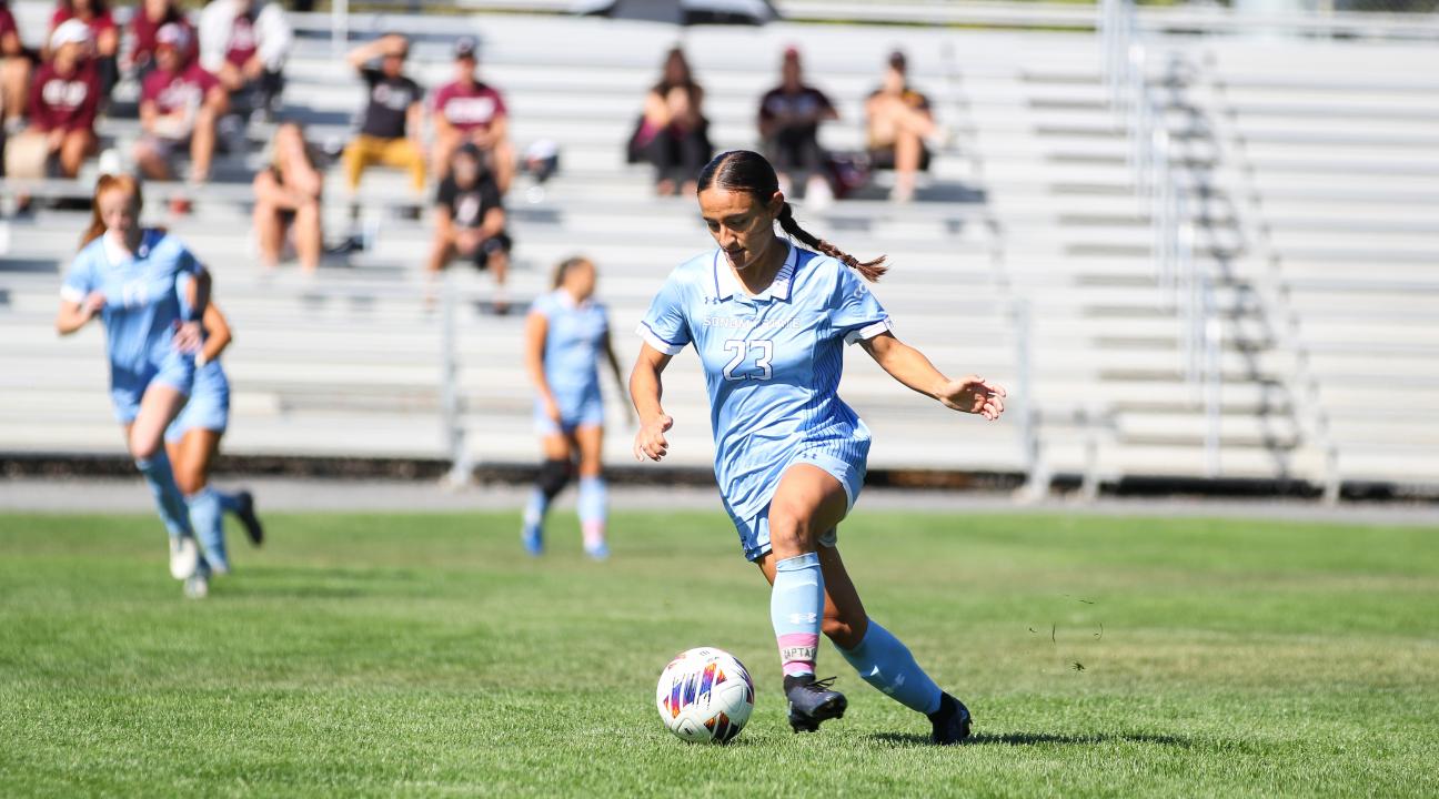 An SSU student kicking a ball while playing on the Women's Soccer team
