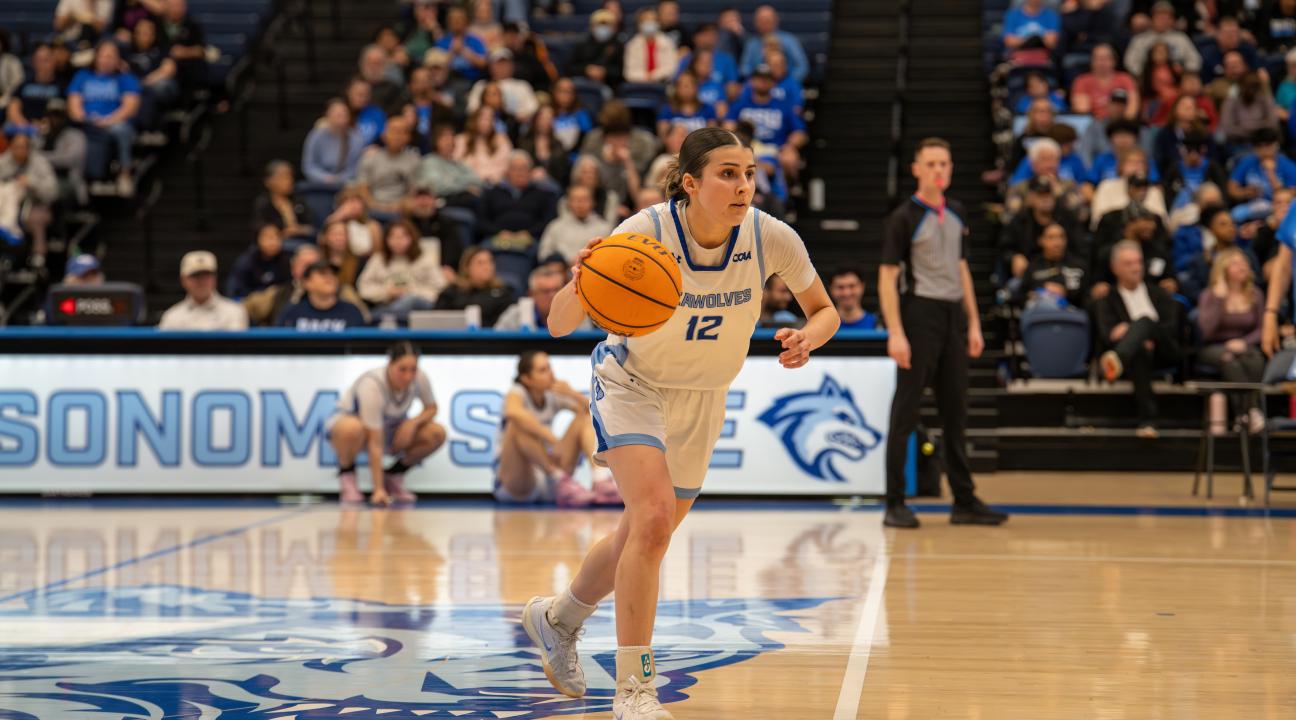 An SSU student dribbling a basketball while playing on the Women's Basketball team