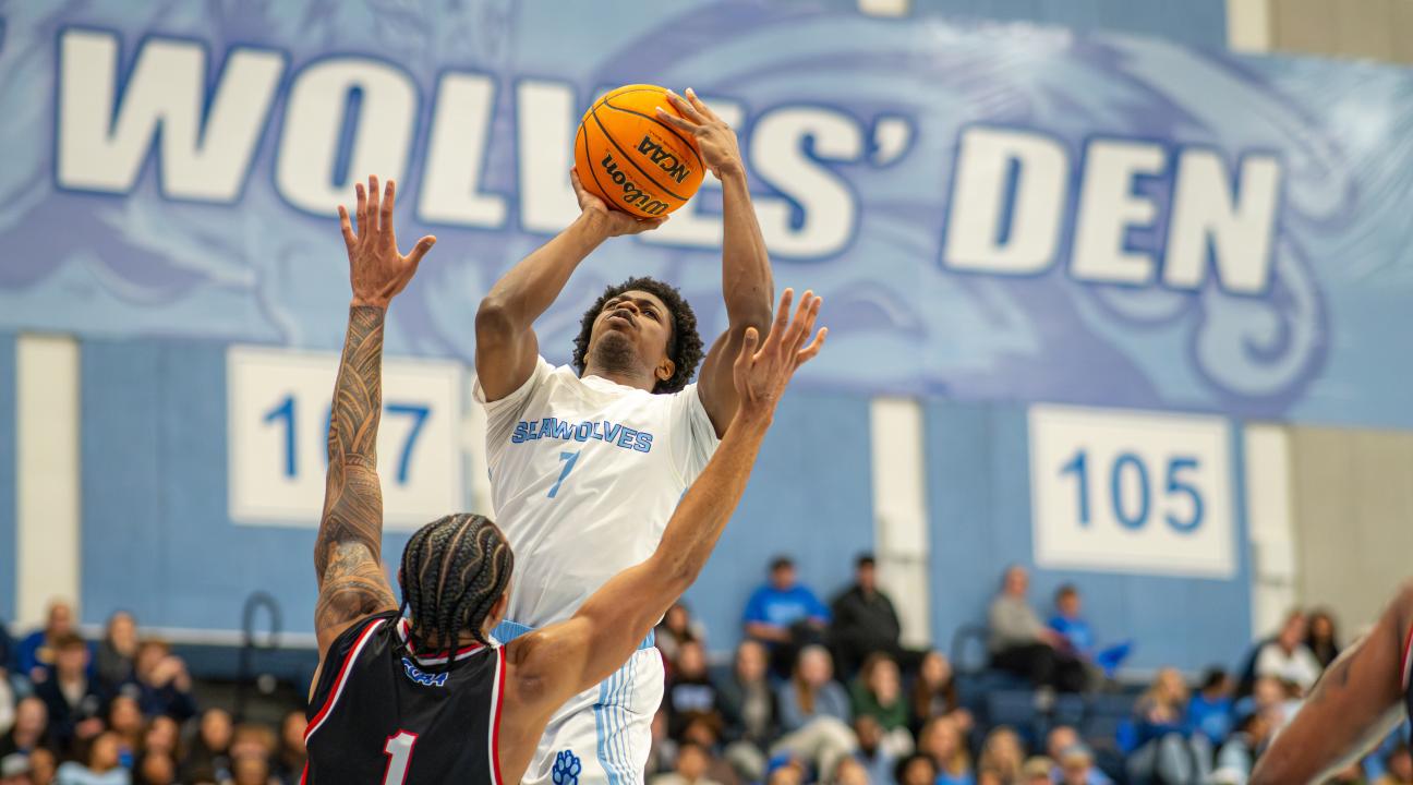 An SSU student dunking a basketball while playing on the Men's Basketball team