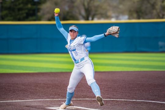 An SSU student pitching a ball while playing on the Women's Softball team