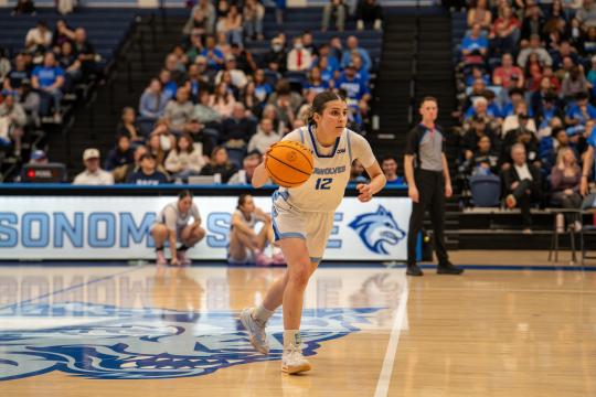 An SSU student dribbling a basketball while playing on the Women's Basketball team