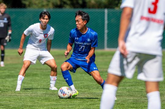 An SSU student kicking a ball while playing on the Men's Soccer team
