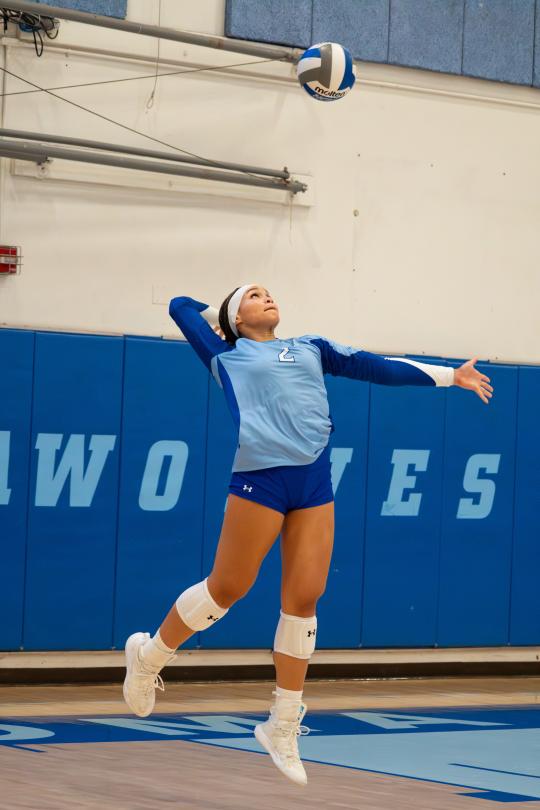 An SSU student serving a volleyball while playing on the Women's Volleyball team